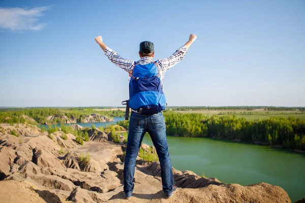 Foto uit achterkant van jonge toeristische met rugzak met handen tegen de achtergrond van berglandschap, lake — Stockfoto