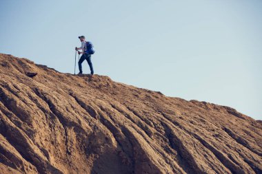 Adam sırt çantası ve baston ile arka üzerinden uzaktan görüntü