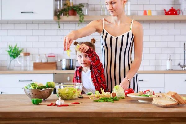 Fotka ženy s její dcerou krájení zeleniny v kuchyni — Stock fotografie