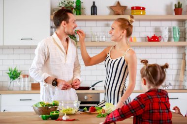 Mutlu anne ve kızları sebze ile bir masada fotoğrafı