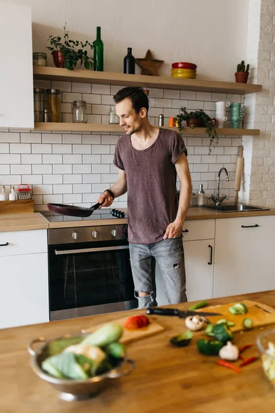 Obraz člověka s pánev v rukou v kuchyni — Stock fotografie