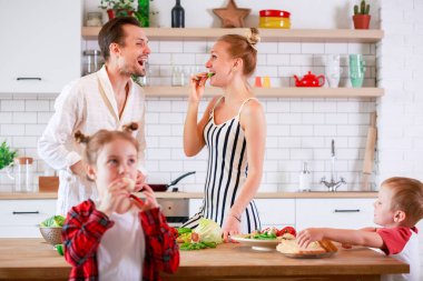Anne ile oğlu ve kızı kahvaltı hazırlarken fotoğrafı
