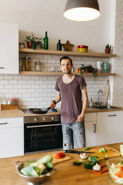 Obraz člověka s pánev v rukou v kuchyni — Stock fotografie