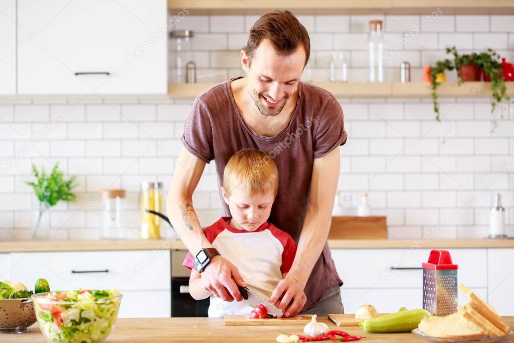 Image of man with son cooking vegetables