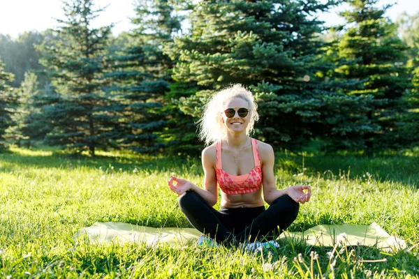 Immagine di giovane atleta che pratica yoga sul tappeto — Foto Stock