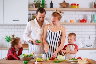 Genç Anne ve babanın oğlu ve kızı kahvaltı hazırlarken ile fotoğraf
