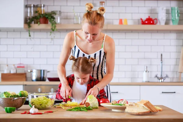 Genç Anne ile kızı evinde mutfakta yemek görüntüsünü