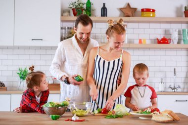 Genç Anne ve babanın oğlu ve kızı kahvaltı hazırlarken ile görüntü