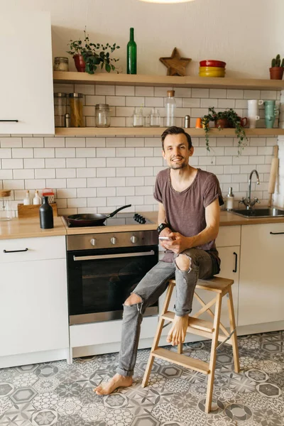 Kızartma tavası mutfakta telefonda konuşurken onun elinde olan brunet adam portresi