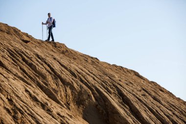 Sırt çantası ve baston tepe üzerinde atlet görüntüsünü