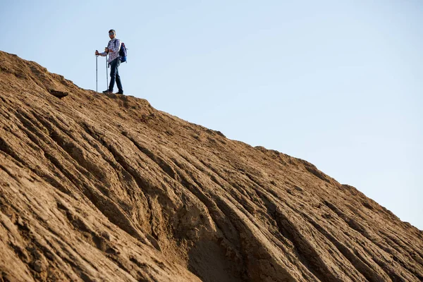 Sırt çantası ve baston tepe üzerinde atlet görüntüsünü
