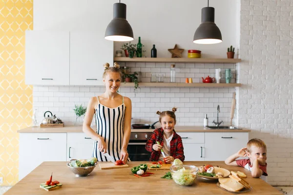 Zdjęcie z piękna kobieta z jej córka krojenia warzyw w kuchni — Zdjęcie stockowe