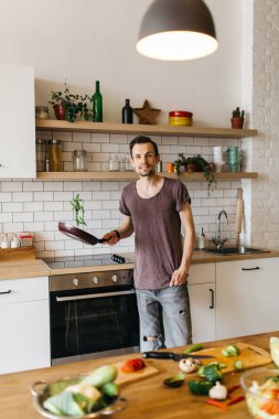 Kızartma tavası mutfakta elinde olan adam görüntüsünü