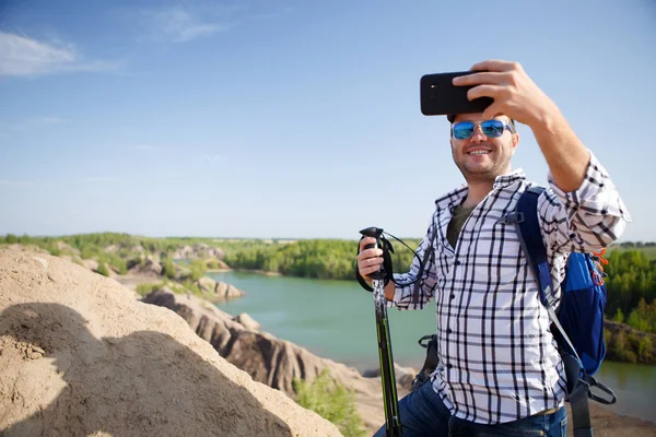 Foto de turista con mochila fotografiando en la colina — Foto de Stock