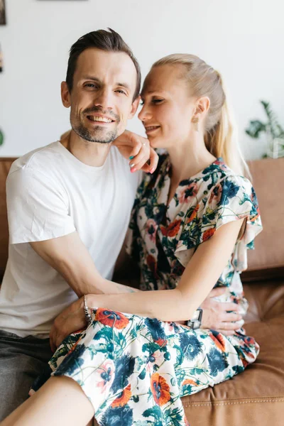 Photo of couple in love sitting on leather sofa — Stock Photo, Image