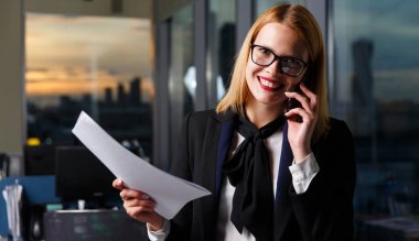 Photo of smiling woman wearing glasses talking on phone clipart