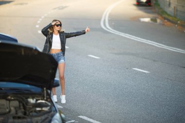 Genç sarışın ile yükseltilmiş el ayakta kırık araba açık kukuleta ile yakın görüntü