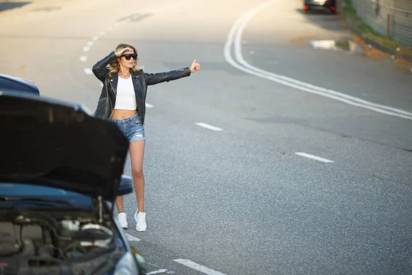 Genç sarışın ile yükseltilmiş el ayakta kırık araba açık kukuleta ile yakın görüntü