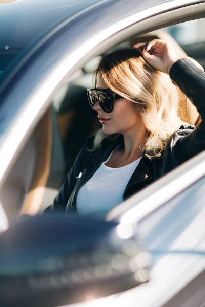 Imagen de mujer con gafas de sol sentada en coche . —  Fotos de Stock