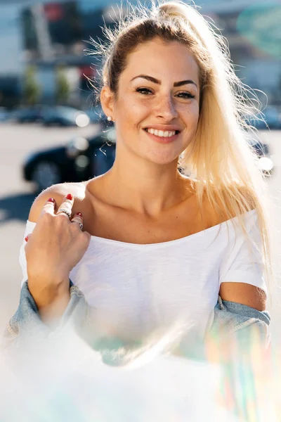 Portrait of young blonde on blurred background in city — Stock Photo, Image