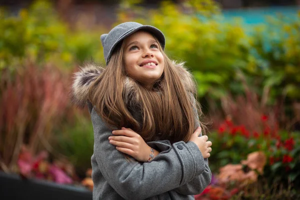 灰色の帽子とコートで笑顔の少女の写真 — ストック写真
