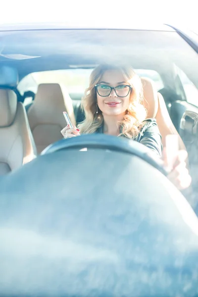 Imagen de mujer feliz con gafas conduciendo coche negro —  Fotos de Stock