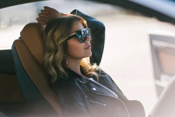 Фотография на стороне блондинки с длинными волосами за рулем в автомобиле . — стоковое фото