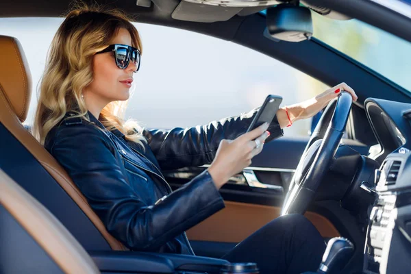 Fotoğraf yan sarışın ile cep telefonu arabada oturan siyah gözlük