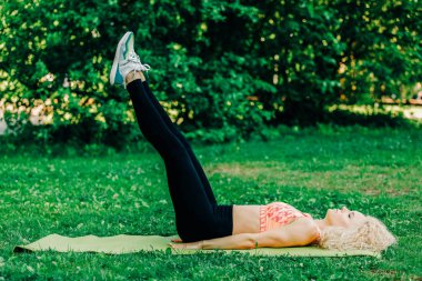 Kıvırcık saçlı genç görüntü pratik yoga halı üzerinde kadın spor 