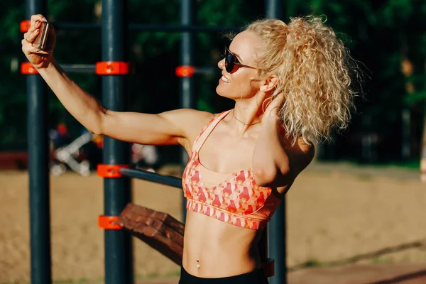 Foto van lachende sport vrouw dragen van een zonnebril doet selfie in — Stockfoto