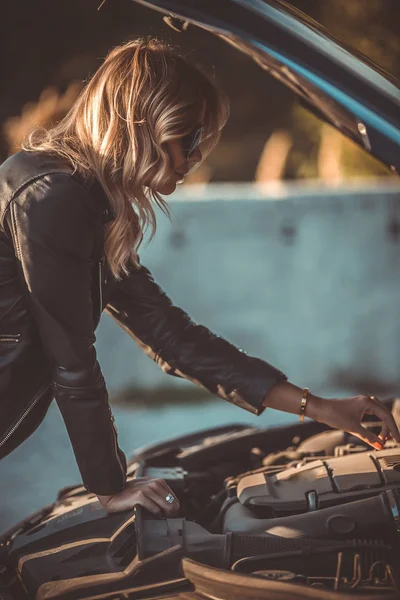 Фото со стороны молодой женщины рядом со сломанным автомобилем с открытым капотом — стоковое фото