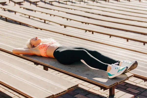 Sport nő gyakorlása padok között a nyári nap képe — Stock Fotó