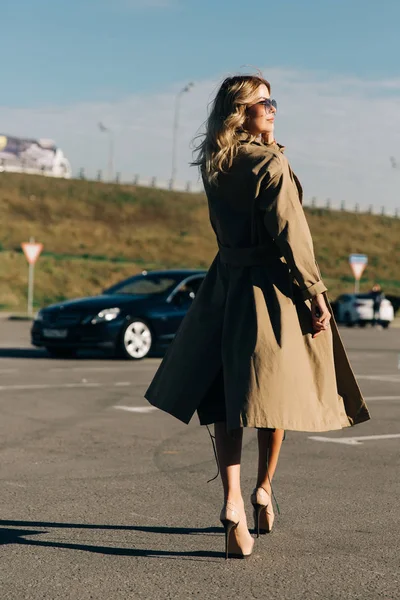 Bild in voller Länge von Tasche der jungen Blondine auf dem Hintergrund des schwarzen Autos — Stockfoto