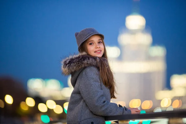 灰色の帽子、コート ウォーター フロント スポット ライトの背景の上に女の子の写真がぼやけて背景 — ストック写真