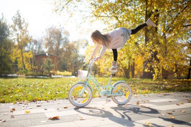 Yükseltilmiş bacak binicilik bisiklet Sonbahar Park ile etek kız fotoğrafı