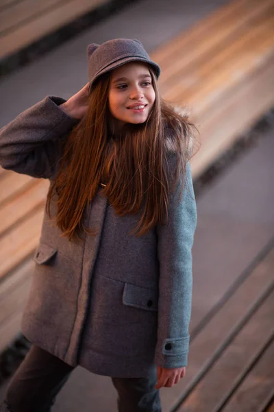 Foto von Mädchen mit grauem Hut und Mantel auf dem Hintergrund von Flecken, Lichtern, verschwommenem Hintergrund — Stockfoto