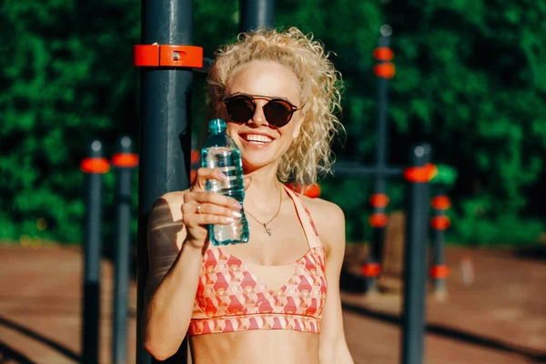 Photo de femme sportive portant des lunettes de soleil avec bouteille d'eau ne — Photo