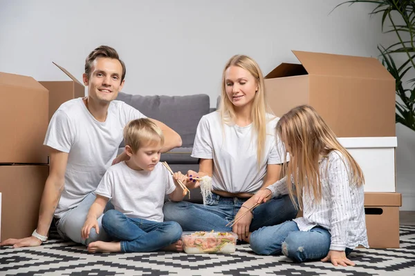 图为一对夫妇带着孩子在纸板箱里的地板上吃米饭, 虾坐在地板上 — 图库照片