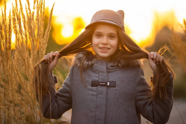 Foto von Mädchen mit grauem Hut und Mantel auf verschwommenem Hintergrund in der Stadt — Stockfoto