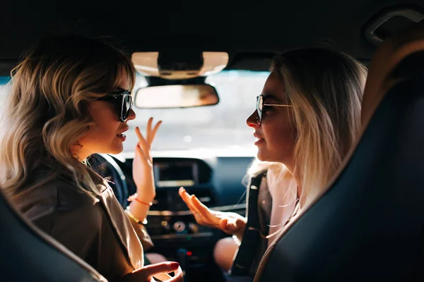 Фото двух говорящих женщин, сидящих в машине на переднем сиденье — стоковое фото