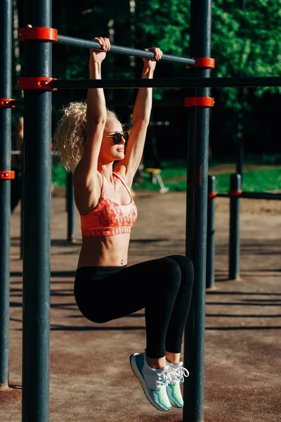 Kép göndör szőke sport húzza fel a sport szimulátor Park — Stock Fotó