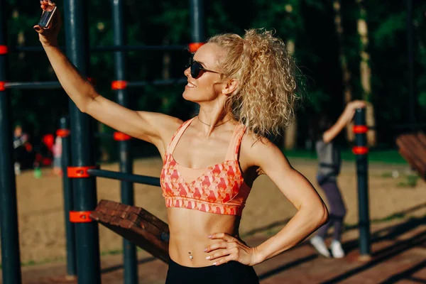 Fénykép a mosolygó sport nő visel csinál selfie napszemüveg — Stock Fotó