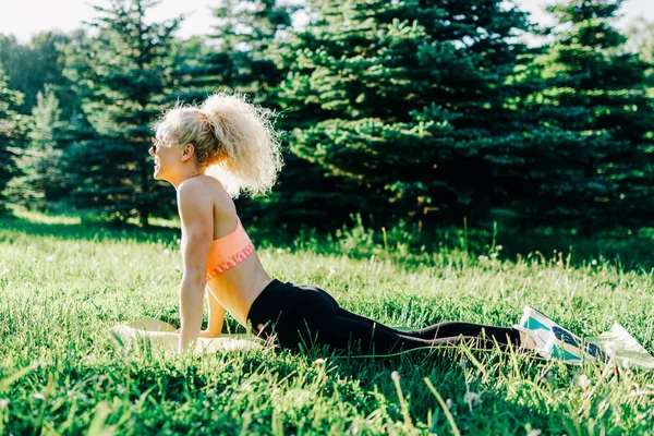 Foto van jonge curly-haired sport vrouw beoefenen van yoga op tapijt — Stockfoto