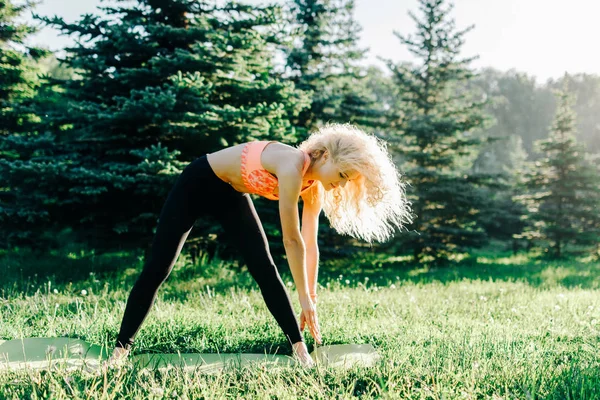 Foto av unga curly-haired sport kvinna utövar yoga på matta — Stockfoto