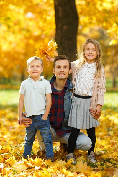 Image of young father with daughter and son in autumn park walking — Stock Photo, Image