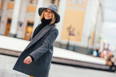 Genç Sarışın şehir binaların bulanık arka planda gri paltolu fotoğrafı