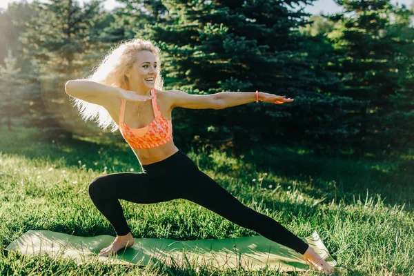 Beeld van jonge curly-haired sport vrouw beoefenen van yoga op tapijt — Stockfoto