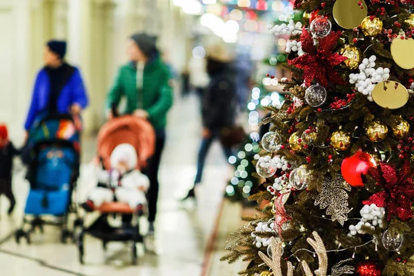 Foto der geschmückten Fichte im Geschäft auf dem Hintergrund von Müttern mit Kinderwagen — Stockfoto