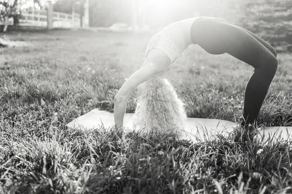 Photo of young curly woman in sunglasses lying on rug in park — Stock Photo, Image