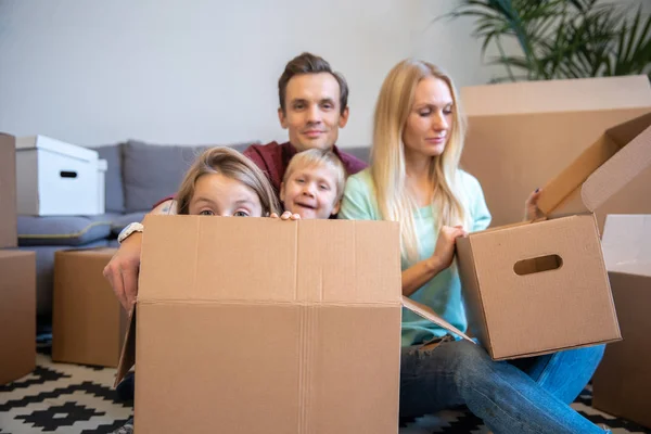 Kép fiatal szülők és gyermekek között, karton dobozok, új lakás — Stock Fotó